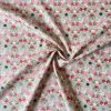 Mirrored directional floral hare print fabric on warm grey ground in shades of pink, red, green, ivory, purple