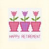 3 pink flowers with green leaves in three pink flower pots with happy retirement underneath